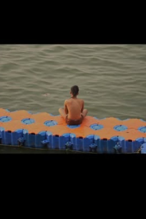 Visitor sitting on a floating platform by the ghats